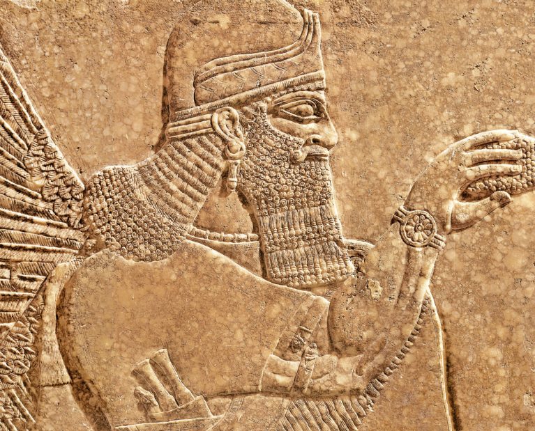 Assyrian wall relief of winged genius, old carving panel from Middle East. Remains of fine art of ancient Babylonian and Sumerian civilization in Mesopotamia. History and mythology of Iran and Iraq.